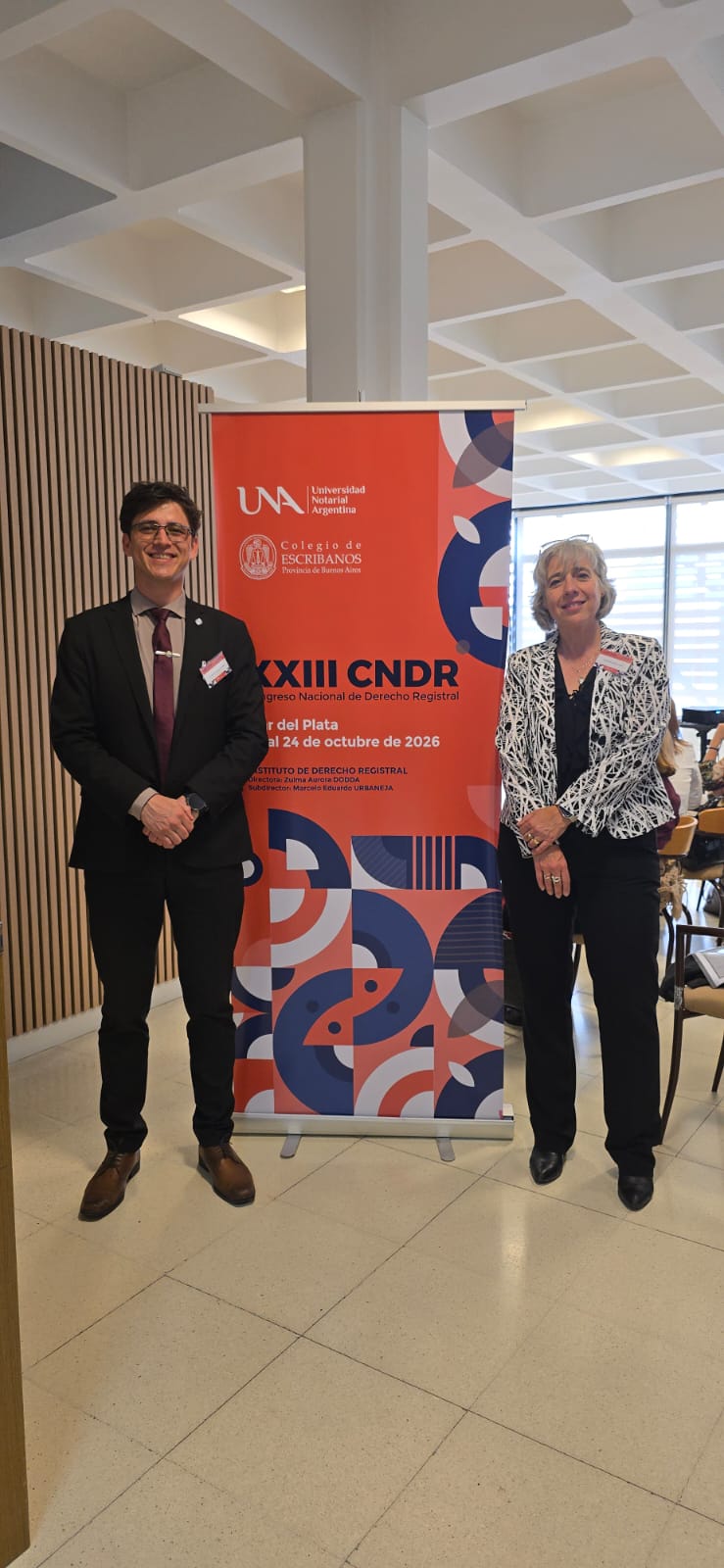 María Laura Szymanski y Guillermo O'Connor junto al cartel del XXIII Congreso Nacional de Derecho Registral