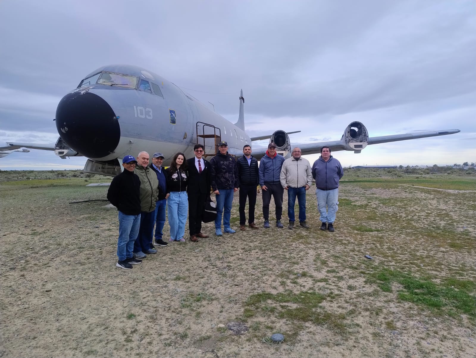 Integrantes del Ateneo Jurídico Territorial junto a miembros del Instituto Aeronaval, sede Trelew, frente a un avión del instituto, el 8 de octubre de 2026